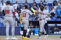 Atlanta Braves' Marcell Ozuna, right, is congratulated by teammates after Ozuna hit a home run scoring Ronald Acuna Jr. (13) and Matt Olson (28) during the ninth inning of a baseball game against the Miami Marlins, Sunday, April 14, 2024, in Miami. (AP Photo/Wilfredo Lee)