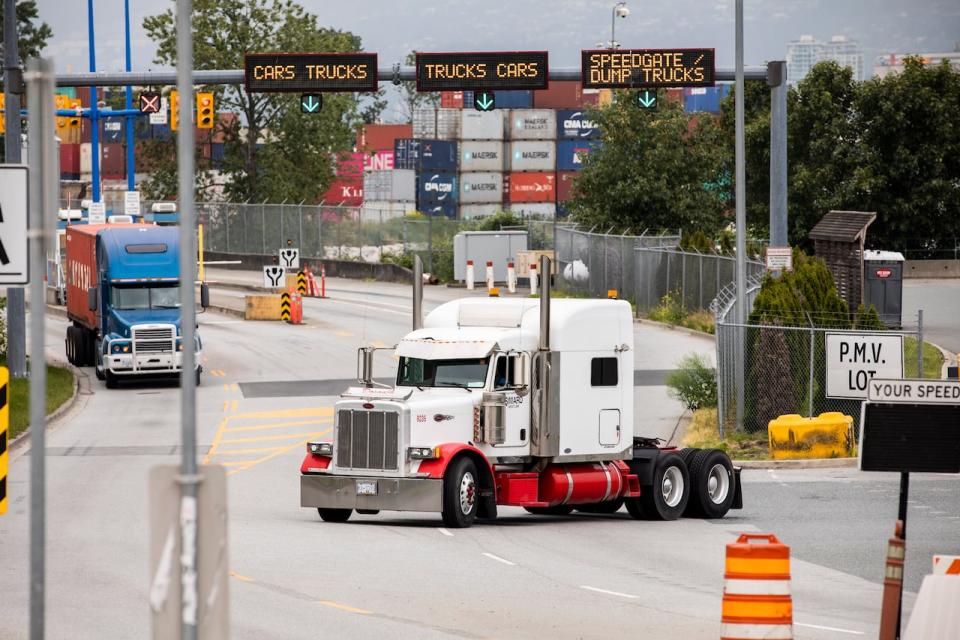 Container transport trucks are seen at the entrance to the Port of Vancouver on May 29, 2019. 