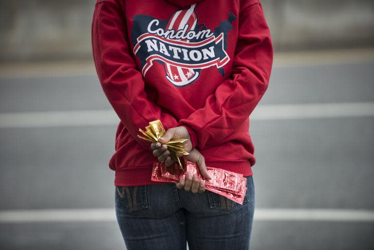 A volunteer with AIDS Healthcare Foundation waits for cars to stop to hand out free condoms on May 24, 2013 in Washington