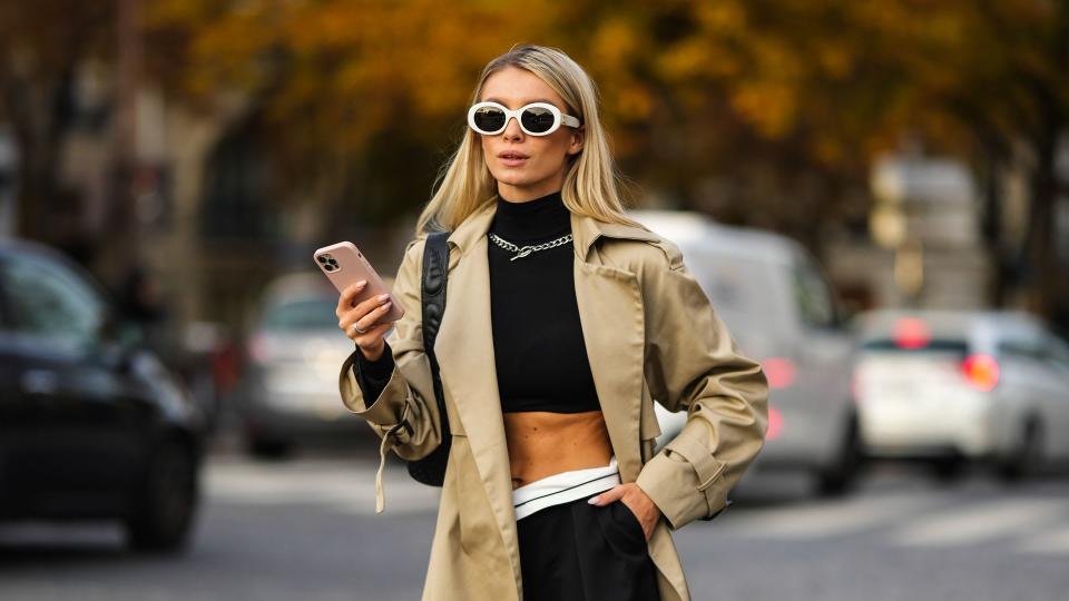 Woman wearing a trench coat with a crop top 