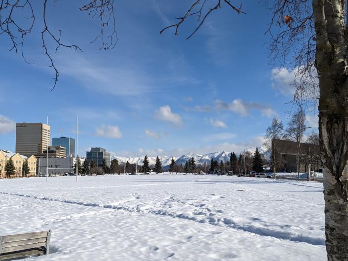 a view of snowy downtown anchorage with mountains in the background