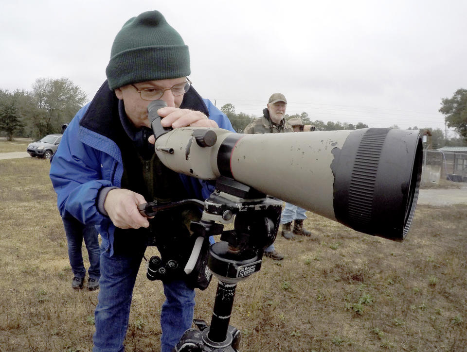 FILE - In this Dec. 19, 2016, file photo, Alan Knothe finds a group of birds near the sewage treatment plant in Fort Walton Beach, Fla., while conducting the annual Christmas Bird Count. It's been 120 years since New York ornithologist Frank Chapman launched his Christmas Bird Count as a bold new alternative to what had been a longtime Christmas tradition of hunting birds. And the annual count continues, stronger and more important than ever. (Nick Tomecek /Northwest Florida Daily News via AP, File)