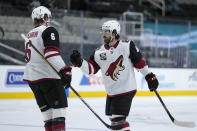 Arizona Coyotes right wing Conor Garland (83) is congratulated by Jakob Chychrun (6) after scoring a goal against the San Jose Sharks during the second period of an NHL hockey game Friday, May 7, 2021, in San Jose, Calif. (AP Photo/Tony Avelar)