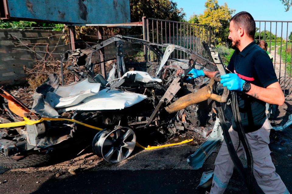 PHOTO: A civil defense worker carries parts of a destroyed car following an Israeli drone strike in the southern town of Bazouriyeh, Lebanon, Jan. 20, 2024.  (Mohammad Zaatari/AP)