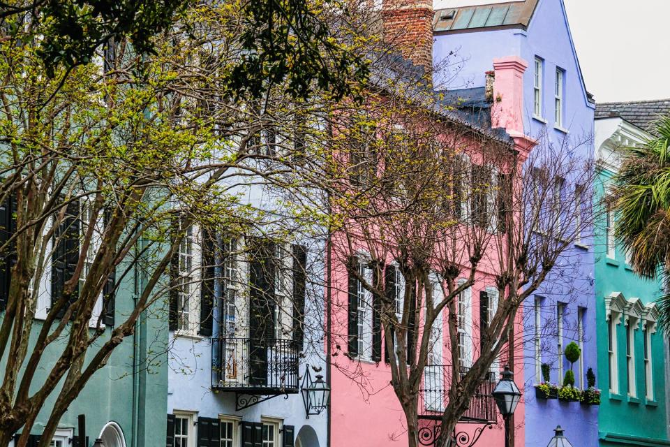 Brightly painted facades, gas lanterns and wrought iron balconies decorate the facades of homes along Charleston's Rainbow Row district.