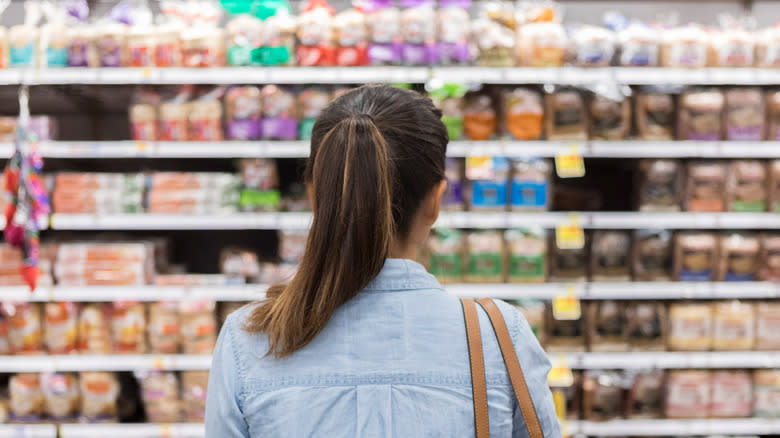 Woman looking at shelved bread