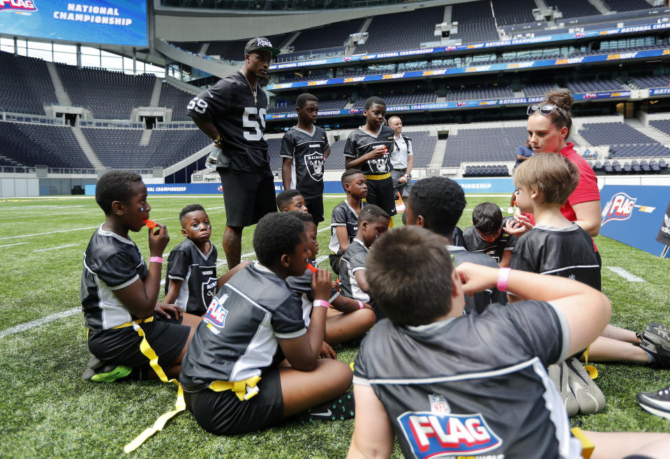 Tahir Whitehead from Oakland Raiders coaches a young team during the final tournament for the UK's NFL Flag Championship, featuring qualifying teams from around the country, at the Tottenham Hotspur Stadium in London, Wednesday, July 3, 2019. The new stadium will host its first two NFL London Games later this year when the Chicago Bears face the Oakland Raiders and the Carolina Panthers take on the Tampa Bay Buccaneers. (AP Photo/Frank Augstein)
