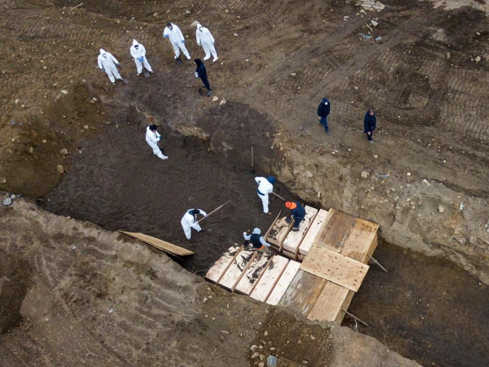 coronavirus covid 19 burial trenches inmates burying unclaimed bodies wooden caskets hart island potters field new york city cemetery nyc bronx april 9 2020 04 09T164235Z_1389564795_RC241G91KIPT_RTRMADP_3_HEALTH CORONAVIRUS USA HART ISLAND.JPG