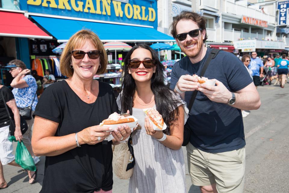 Long-time Seafood Festival patrons Bette-Jean Tousley, Laura Barrero and Elliot Tousley show off their packed lobster rolls at the 34th Hampton Beach Seafood Festival.