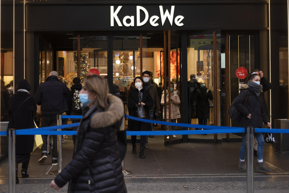 Customers enter and leave the KaDeWe department store a day before new restrictions begin in Berlin, Germany, Tuesday, Dec. 15, 2020. Chancellor Angela Merkel and the governors of Germany's 16 states agreed Sunday to step up the country's lockdown measures beginning Wednesday and running to Jan. 10 to stop the exponential rise of COVID-19 cases. (AP Photo/Markus Schreiber)