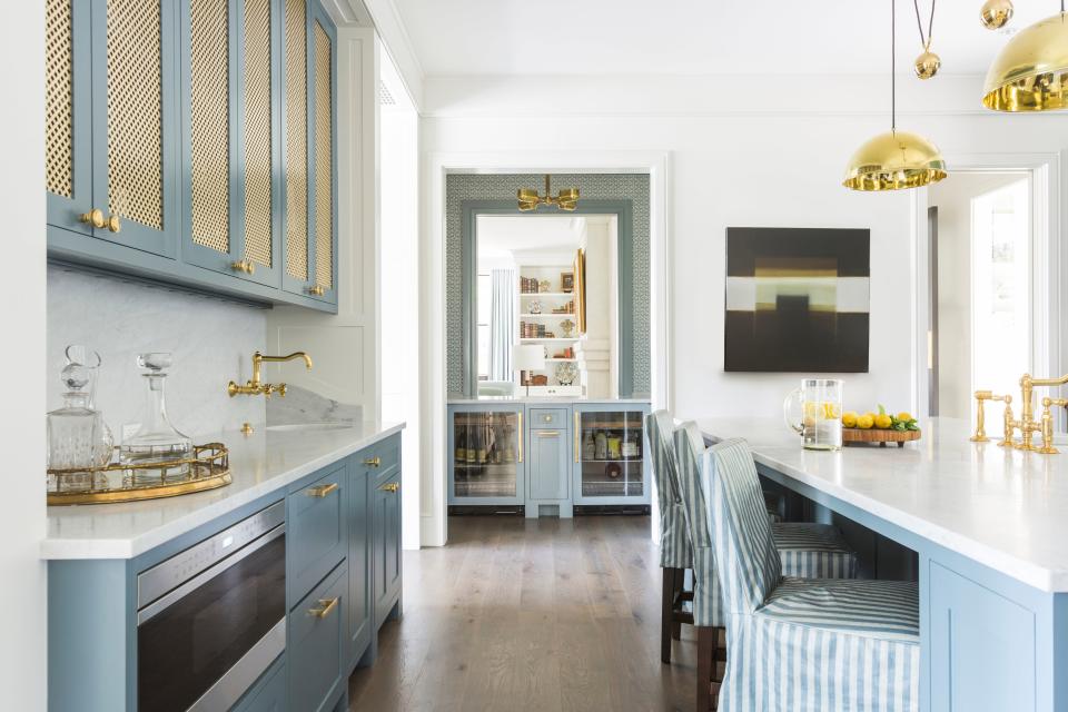 A soft baby blue color (made from a custom mix of blue and gray paint) seen in this Lucas/Eilers Design Associates project plays off the shiny gold hardware to give the whole place a sense of cheerfulness.