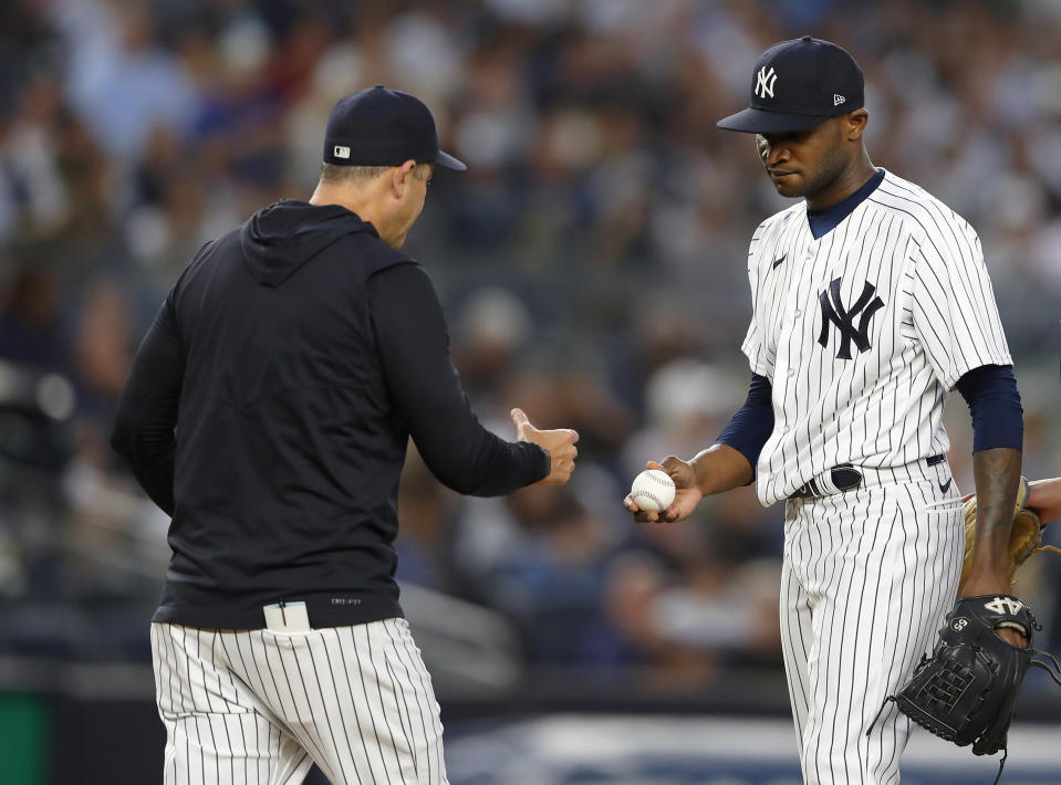 New York Yankees manager Aaron Boone takes the ball from starting pitcher Domingo German during the fourth inning of the team's baseball game against the Seattle Mariners. Thursday, June 22, 2023, in New York. (AP Photo/Noah K. Murray)