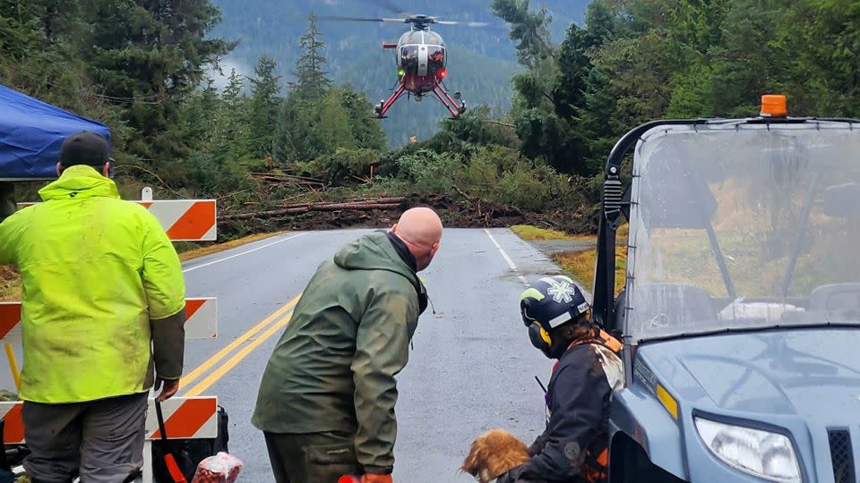 A helicopter arrives as search and rescue dogs and their handlers stand by on Wednesday, November 22. - Willis Walunga/Division of Homeland Security and Emergency Management/AP