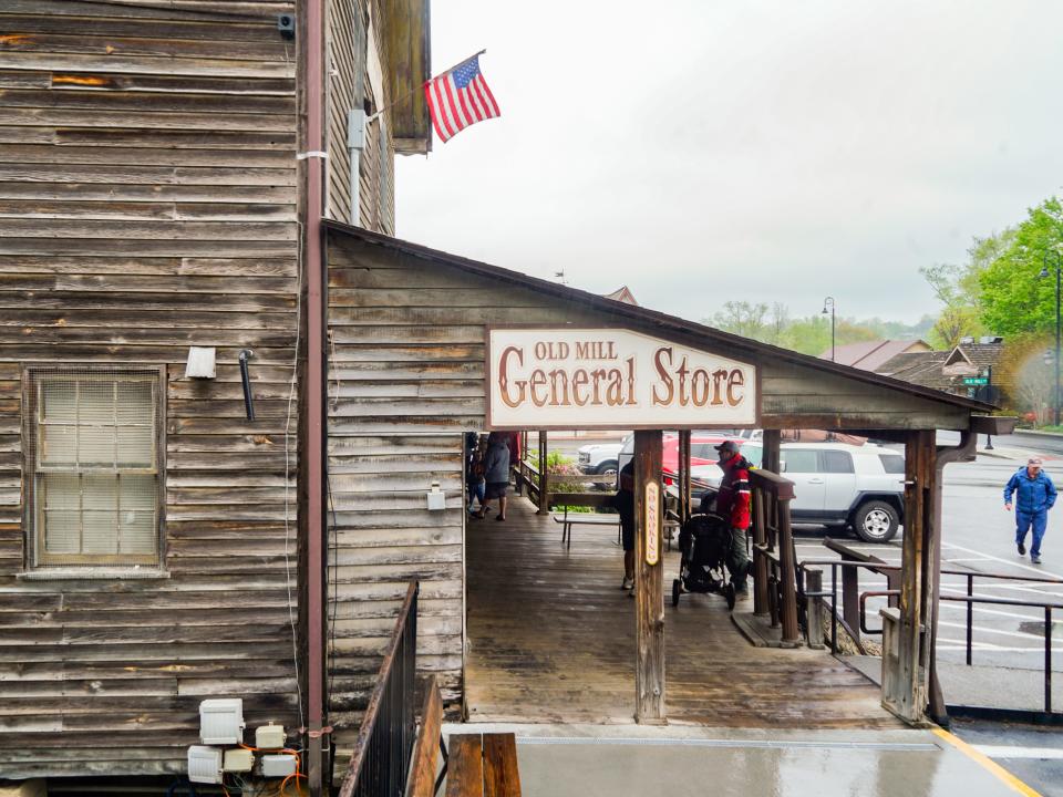 A brown building with a sign that says General Store and gray skies in the background. An American flag hangs from the top of the facade.