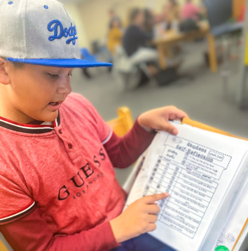 Third grader Juan Antonio Espiricueta Jr. uses his WIN (What I Need) Notebook. The physical binder is used by kindergarten through fourth graders at Calabasas School to track progress towards academic goals for the school year. (Jillian Kuhlmann/KnowledgeWorks) 