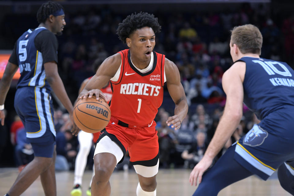 Houston Rockets forward Amen Thompson (1) dribbles the ball as Memphis Grizzlies guard Luke Kennard (10) defends during the first half of an NBA basketball game Wednesday, Feb. 14, 2024, in Memphis, Tenn. (AP Photo/Brandon Dill)