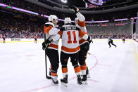 Philadelphia Flyers' Travis Konecny (11) celebrates with Scott Laughton, left, and Nick Seeler, right, after scoring against New Jersey Devils goaltender Kaapo Kahkonen during the second period of an NHL hockey game, Saturday, April 13, 2024, in Philadelphia. (AP Photo/Derik Hamilton)