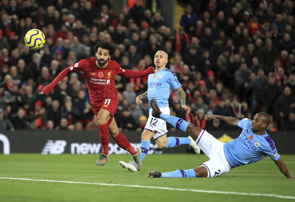 Liverpool's Mohamed Salah, left, scores his side's second goal of the game during the English Premier League soccer match at Anfield, Liverpool, England, Sunday Nov. 10, 2019. (Peter Byrne/PA via AP)