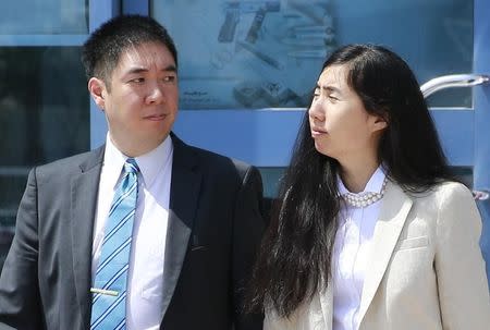 Matthew (L) and Grace Huang, a U.S. couple who were accused of murdering their adopted daughter Gloria, stand outside the entrance of the Court of First Instance after their trial in Doha, March 27, 2014. REUTERS/Mohammed Dabbous