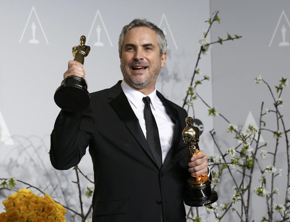 Alfonso Cuaron poses with the award for best director and best film editing for "Gravity" at the 86th Academy Awards in Hollywood