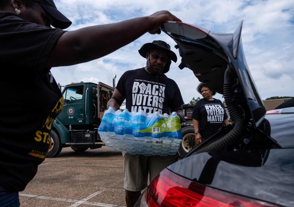 Residents distribute cases of water in Jackson, Miss., on Sept. 3, 2022.
