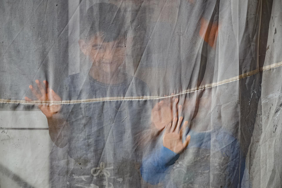 Two young children, nephews of Azime Ali Topchu, 48, playfully pose for a photograph behind a curtain in a village on the outskirts of Burgas, Bulgaria, Monday, Sept. 28, 2020. (AP Photo/Vadim Ghirda)