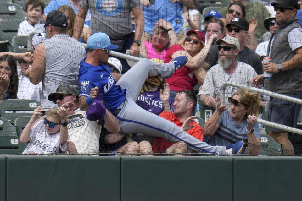 Kansas City Royals third baseman Nick Loftin crashes into the netting and the first row of fans as he failed to make a play on a foul ball hit by Colorado Rockies' Nolan Jones during the second inning of a spring training baseball game Tuesday, March 12, 2024, in Scottsdale, Ariz. (AP Photo/Ross D. Franklin)