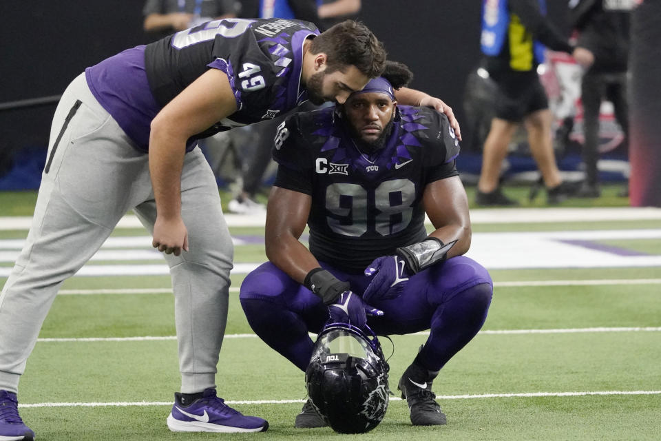 TCU's Connor Lingren (49) consoles teammate Dylan Horton (98) after Kansas State defeated them in the Big 12 Conference championship NCAA college football game, Saturday, Dec. 3, 2022, in Arlington, Texas. (AP Photo/LM Otero)