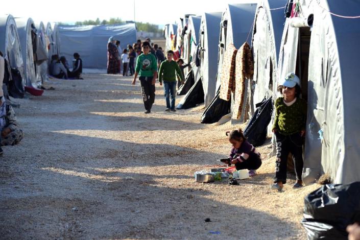 Children walk past tents on October 22, 2014 at Suruc Rojava refugee camp in Sanliurfa, where Sultan Muslim lives with her family, including newborn son Muhammed Obama Muslim (AFP Photo/Ilyas Akengin)