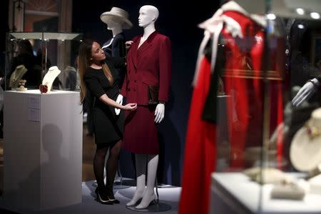 An employee arranges a burgundy wool tweed suit, part of the collection of former British prime minister Margaret Thatcher during an auction preview at Christie's in London, Britain, December 11, 2015. REUTERS/Peter Nicholls