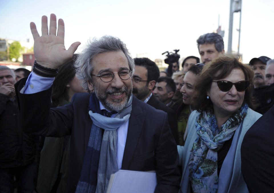 FILE - In this Friday, April 1, 2016 file photo, Can Dundar, the editor-in-chief of opposition newspaper Cumhuriyet, front, and his wife Dilek Dundar walk to the courthouse before the start of his trial in Istanbul. A court in Istanbul convicted exiled journalist Can Dundar on espionage and terror-related charges for a news report and sentencing him to a total of 27 1/2 years in prison. (AP Photo/Emrah Gurel, file)