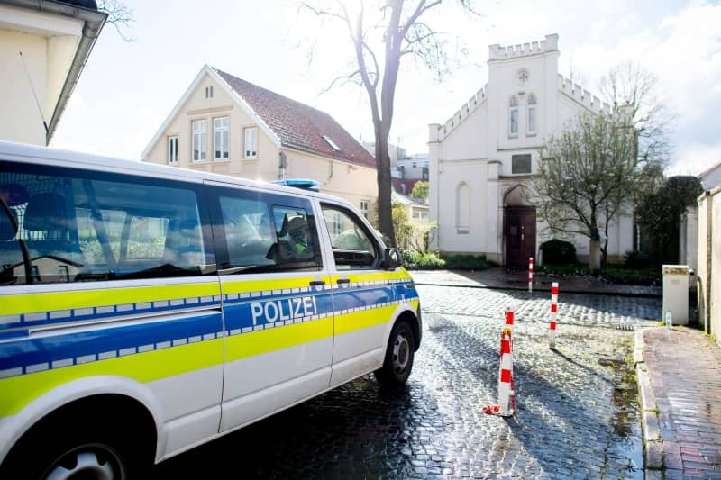 A police vehicle stands in front of the synagogue in the city center. Unknown persons have thrown an incendiary device at a door of the Oldenburg synagogue. According to the police, no one was injured in the attack on Friday afternoon. An entrance door was damaged by the incendiary device. Hauke-Christian Dittrich/dpa