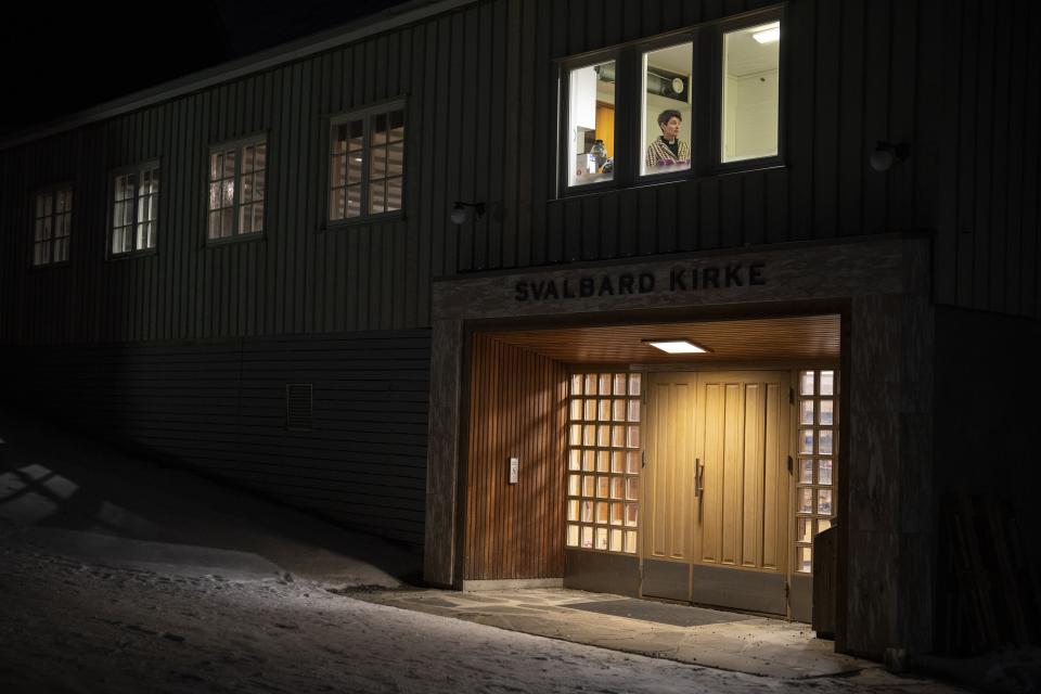 The Rev. Siv Limstrand is pictured at Svalbard Kirke in Longyearbyen, Norway, Sunday, Jan. 8, 2023. Founded for and by coal miners, Svalbard Kirke is literally a beacon in the dark – its sanctuary and fireplace-warmed lounge stay open 24/7 even in winter, when the sun never rises this close to the North Pole. (AP Photo/Daniel Cole)