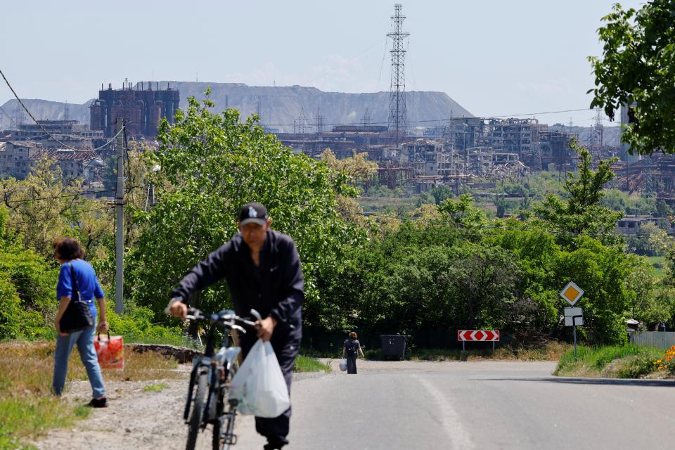A man can be seen wheeling his bicycle in front of the Azovstal steel plant (REUTERS)