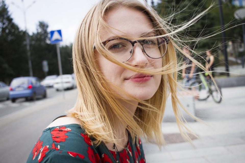 A woman smiles as her hair blows in the wind