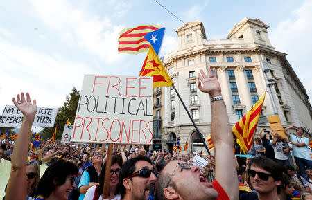 People wave placards and separatist Catalan flags during a demonstration organised by Catalan pro-independence movements ANC (Catalan National Assembly) and Omnium Cutural, following the imprisonment of their two leaders Jordi Sanchez and Jordi Cuixart, in Barcelona, Spain October 21, 2017. REUTERS/Rafael Marchante