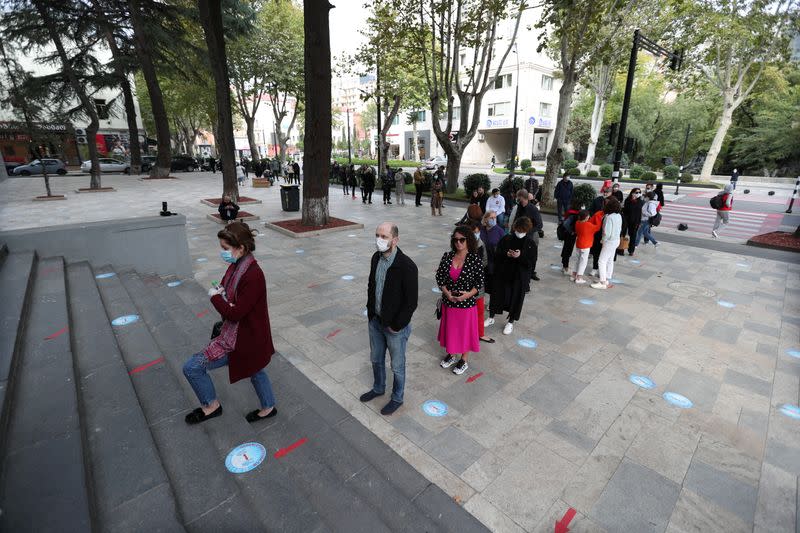 People line up outside a polling station during a parliamentary election in Tbilisi