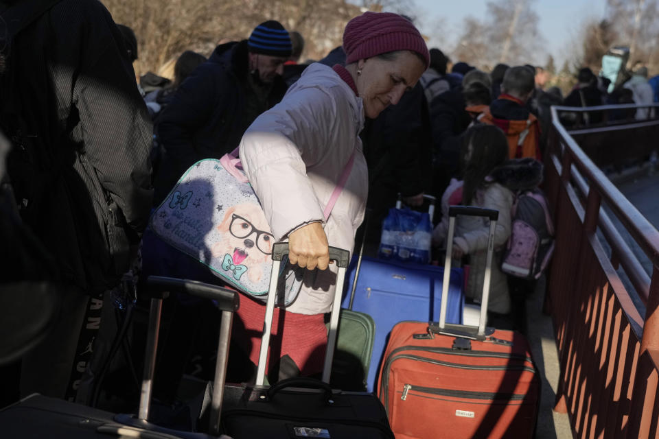 A woman waits in a line to board the train to get back to Ukraine at a railway station in Przemysl, Poland, on Tuesday, March 22, 2022. People from Ukraine could cross the border several times to help with evacuation for refugees, mostly for children. (AP Photo/Sergei Grits)