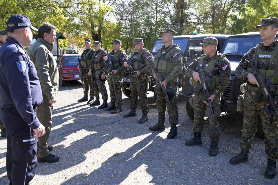 In this photo provided by the Serbian Interior Ministry, Serbian Interior Minister Bratislav Gasic speaks with police officers near the border between Serbia and Hungary, Serbia, Saturday, Oct. 28, 2023. Serbian police have arrested six people and seized automatic weapons after a shooting between migrants near the country's tense border with Hungary killed three people and injured one. (Serbian Ministry of Interior via AP)