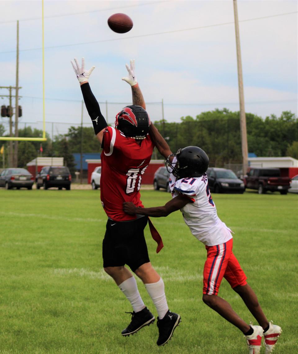 Southeast Michigan Red Storm tight end Tyler Hammack (left) goes up for a catch against the West Michigan Patriots on Saturday, June 11, 2022.