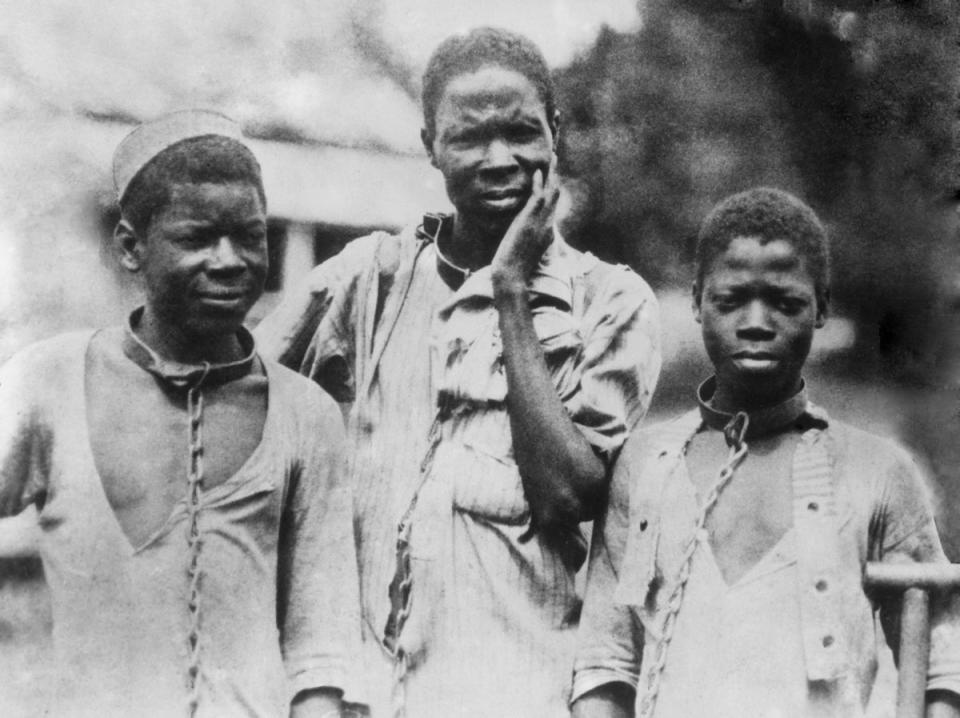 Three enslaved Black men from Ethiopia in iron collars and chains. Photograph taken around 1910 (Getty Images)