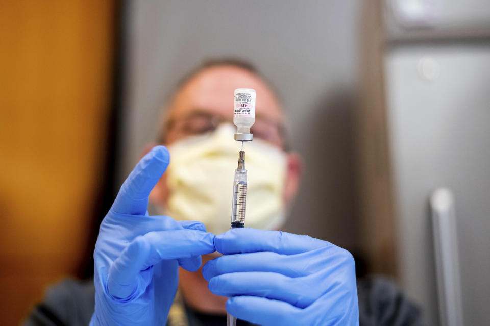 FILE - In this Jan. 12, 2021, file photo a pharmacist draws saline while preparing a dose of Pfizer's COVID-19 vaccine in Sacramento, Calif. Mutations to the virus are rapidly popping up and the longer it takes to vaccinate people, the more likely it is that a variant that can elude current tests, treatments and vaccines could emerge. (AP Photo/Noah Berger, Pool, File)