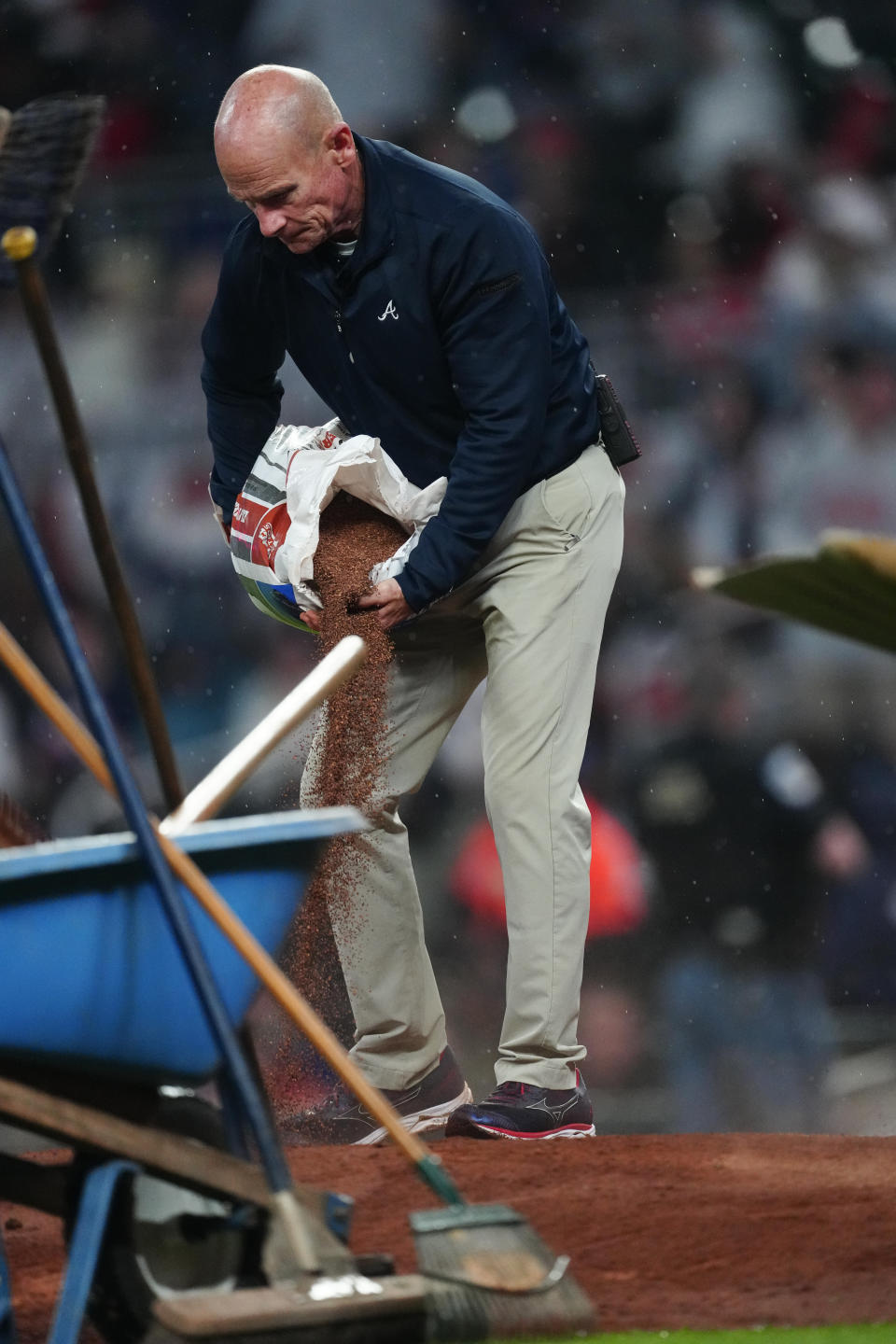Atlanta Braves head groundskeeper Ed Mangan works to dry the pitchers mound before the fifth inning of a baseball game against the New York Mets Tuesday, April 9, 2024, in Atlanta. (AP Photo/John Bazemore)