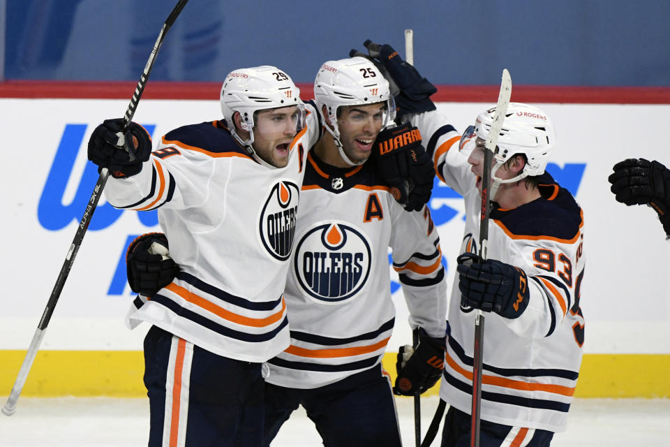 Edmonton Oilers' Leon Draisaitl (29) celebrates his game-winning goal with less than a second left against the Winnipeg Jets with teammates Darnell Nurse (25) and Ryan Nugent-Hopkins (93) in an NHL hockey game, Sunday, Jan. 24, 2021, in Winnipeg, Manitoba. (Fred Greenslade/The Canadian Press via AP)