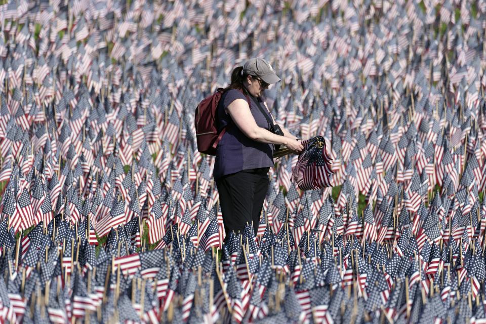 A volunteer tends to the sea of flags placed ahead of Memorial Day on Boston Common, Friday, May 24, 2024, in Boston. AP Photo/Michael Dwyer)