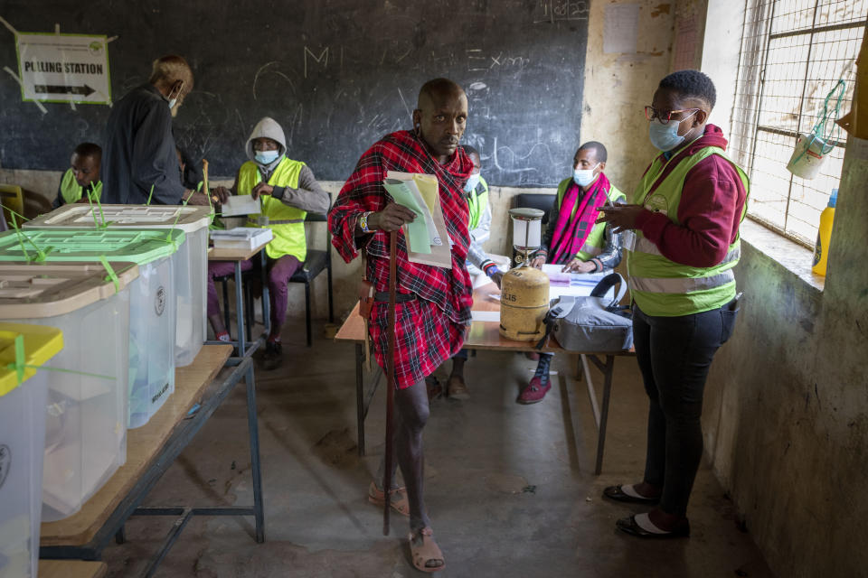 A Maasai man prepares to cast his vote in the general election at a polling station in Esonorua Primary School, in Kajiado County, Kenya Tuesday, Aug. 9, 2022. Polls opened Tuesday in Kenya's unusual presidential election, where a longtime opposition leader who is backed by the outgoing president faces the deputy president who styles himself as the outsider. (AP Photo/Ben Curtis)