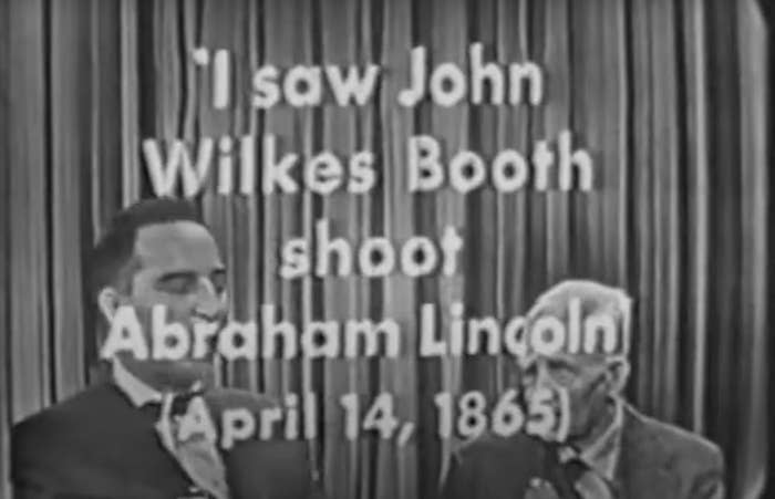 Two men on a vintage TV show; one appears to be recounting his eyewitness account of Abraham Lincoln's shooting