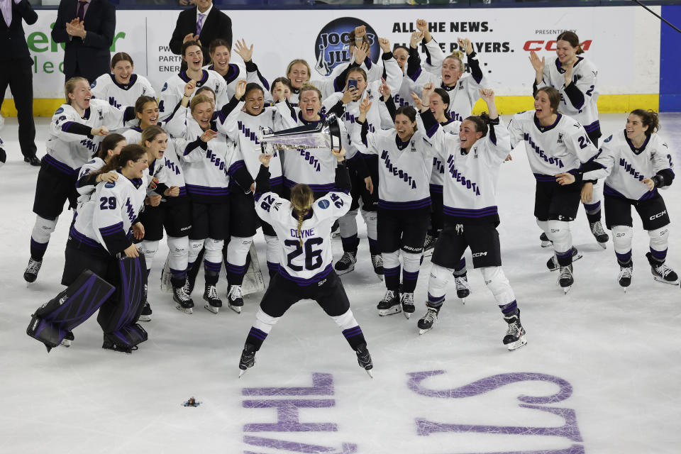 Minnesota captain Kendall Coyne Schofield (26) takes the trophy to her team after defeating Boston to win the PWHL Walter Cup, Wednesday May 29, 2024, in Lowell, Mass. (AP Photo/Mary Schwalm)