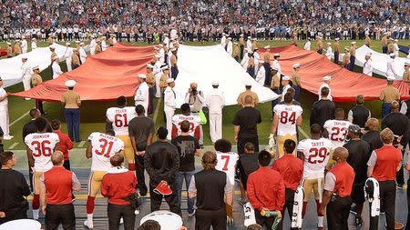 Sep 1, 2016; San Diego, CA, USA; San Francisco 49ers quarterback Colin Kaepernick (7, bottom middle) kneels during the national anthem before the game against the San Diego Chargers at Qualcomm Stadium. Jake Roth-USA TODAY Sports