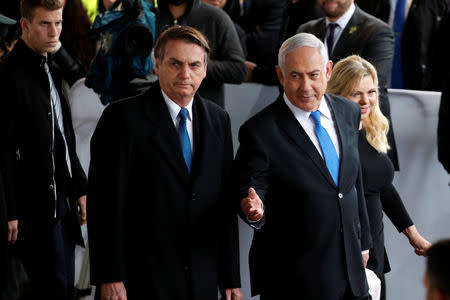 Israeli Prime Minister Benjamin Netanyahu gestures as he stands next to Brazilian President Jair Bolsonaro during a welcoming ceremony upon his arrival in Israel, at Ben Gurion International airport in Lod, near Tel Aviv, Israel March 31, 2019. REUTERS/Ronen Zvulun